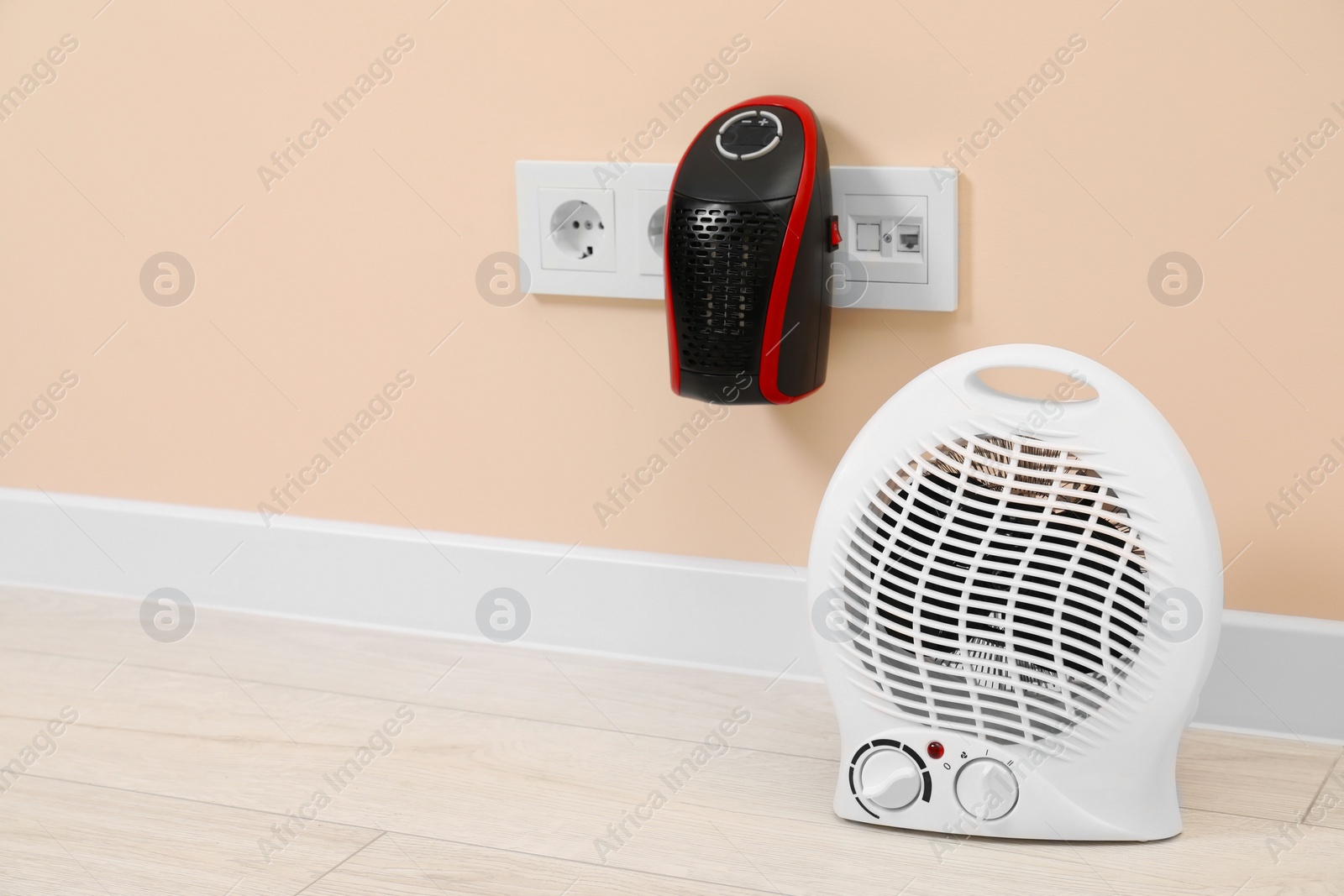 Photo of Modern electric compact and fan heaters indoors, space for text