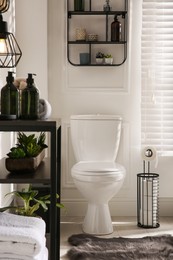 Photo of Modern toilet bowl in comfortable restroom. Interior design