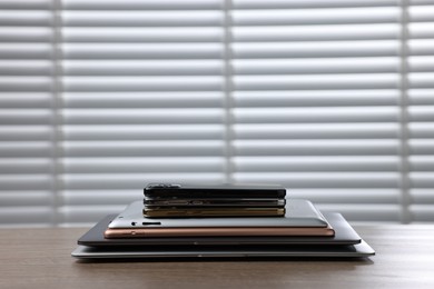 Photo of Many different modern gadgets on wooden table indoors. Space for text