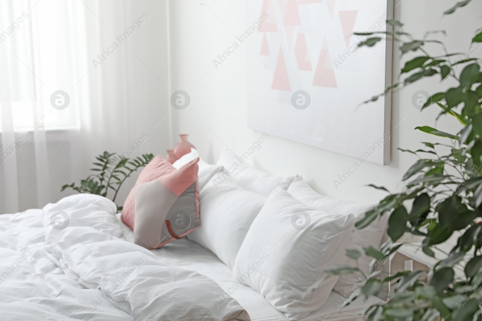 Photo of Comfortable bed with soft pillows in room interior