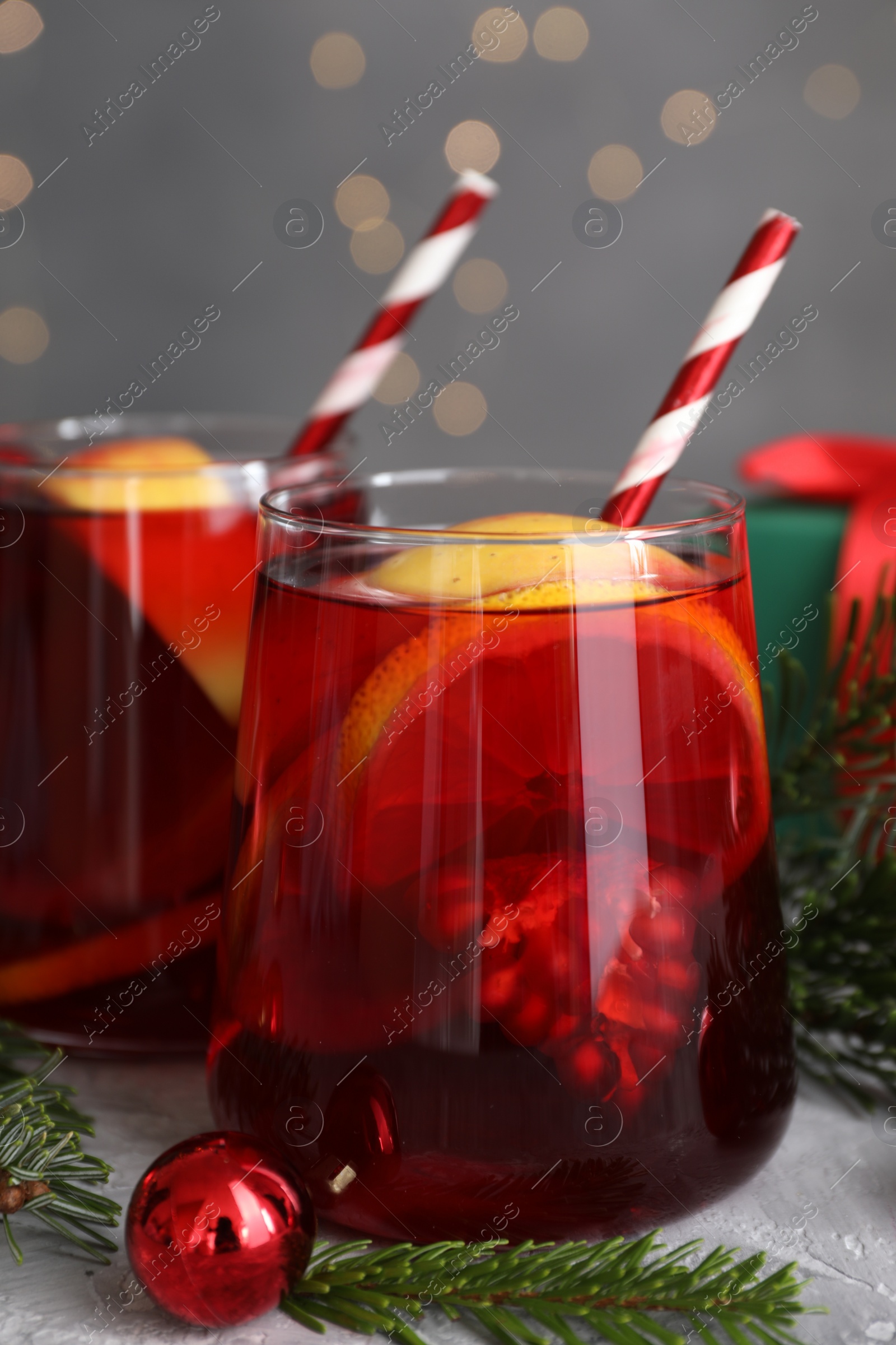 Photo of Delicious Sangria drink in glasses and Christmas decorations on grey table, closeup