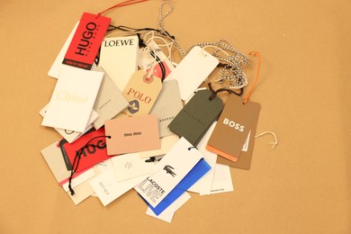 Photo of Leiden, Netherlands - December 6, 2023: Different clothing tags on kraft paper sheet, top view