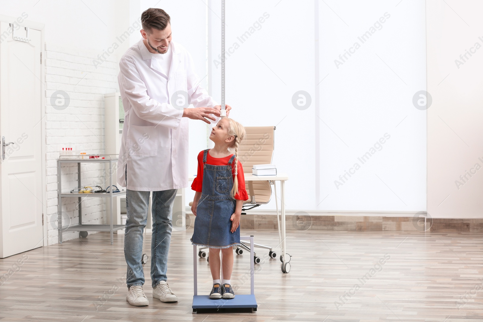 Photo of Doctor measuring little girl's height in hospital
