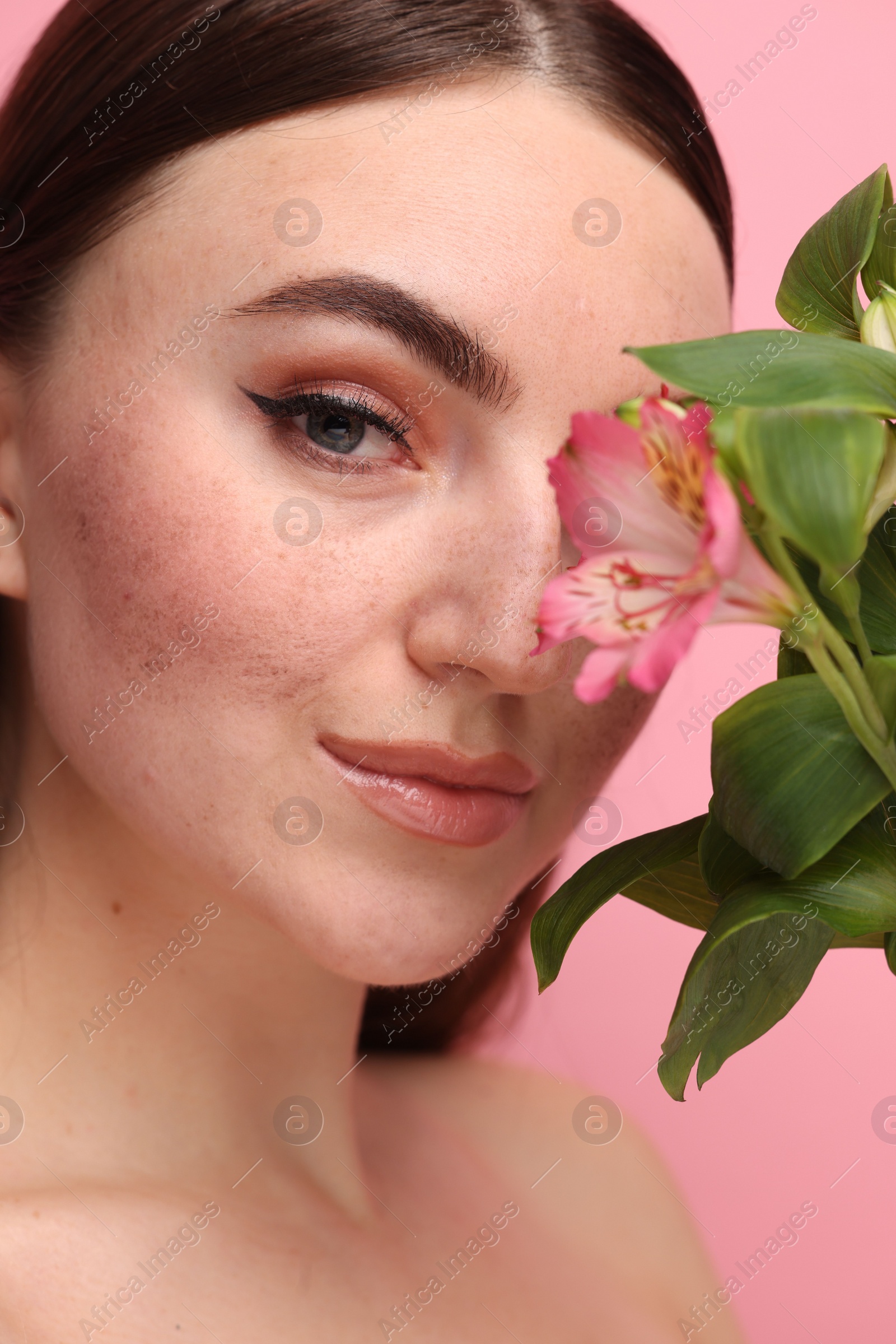 Photo of Beautiful woman with fake freckles and flower, closeup