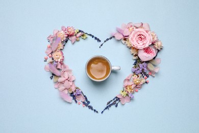 Beautiful heart shaped floral composition with cup of coffee on light background, flat lay