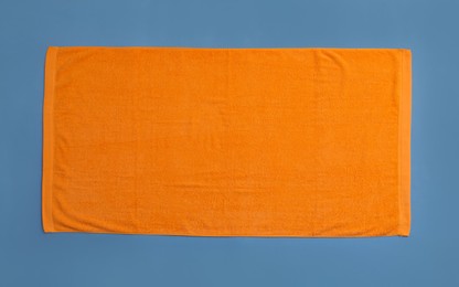 Photo of Orange beach towel on blue background, top view