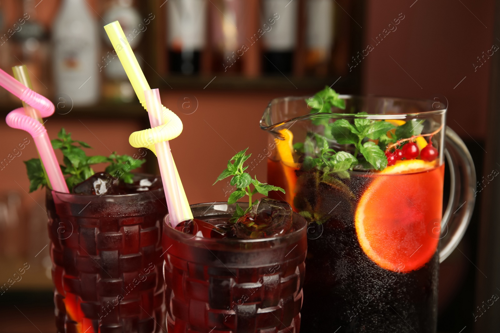 Photo of Glasses and jug with delicious refreshing cocktail, closeup