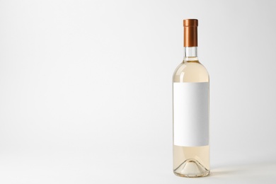 Photo of Bottle of delicious wine with blank label on white background