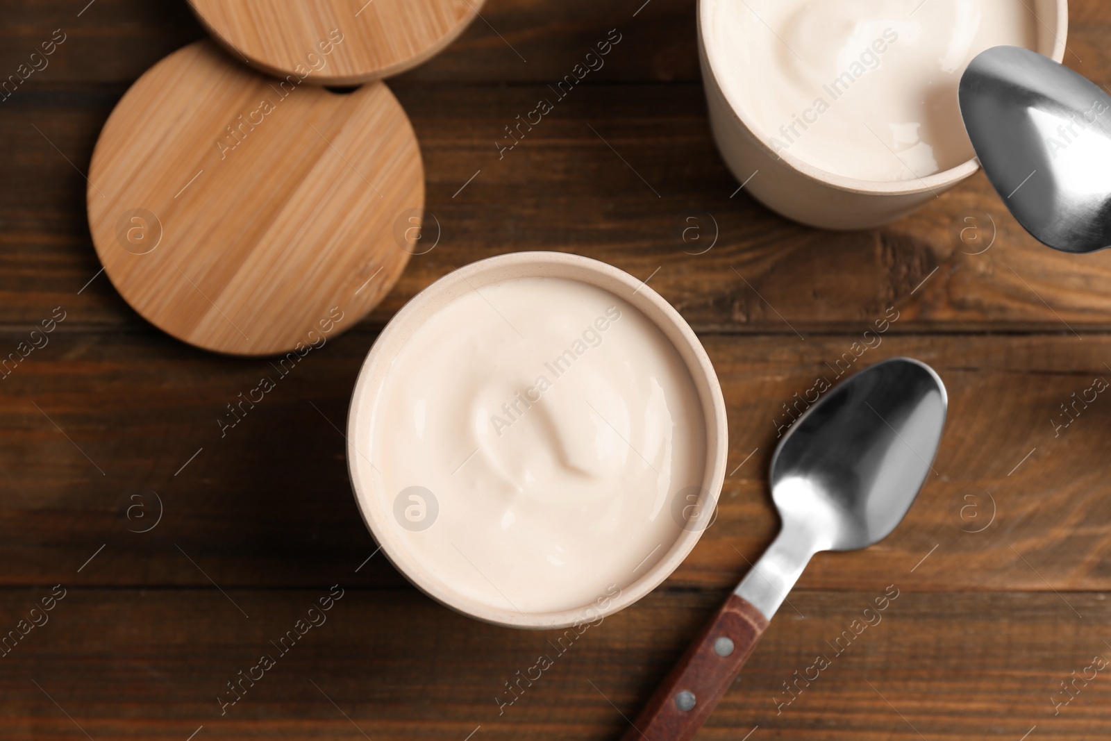 Photo of Bowl with yummy yogurt on wooden table