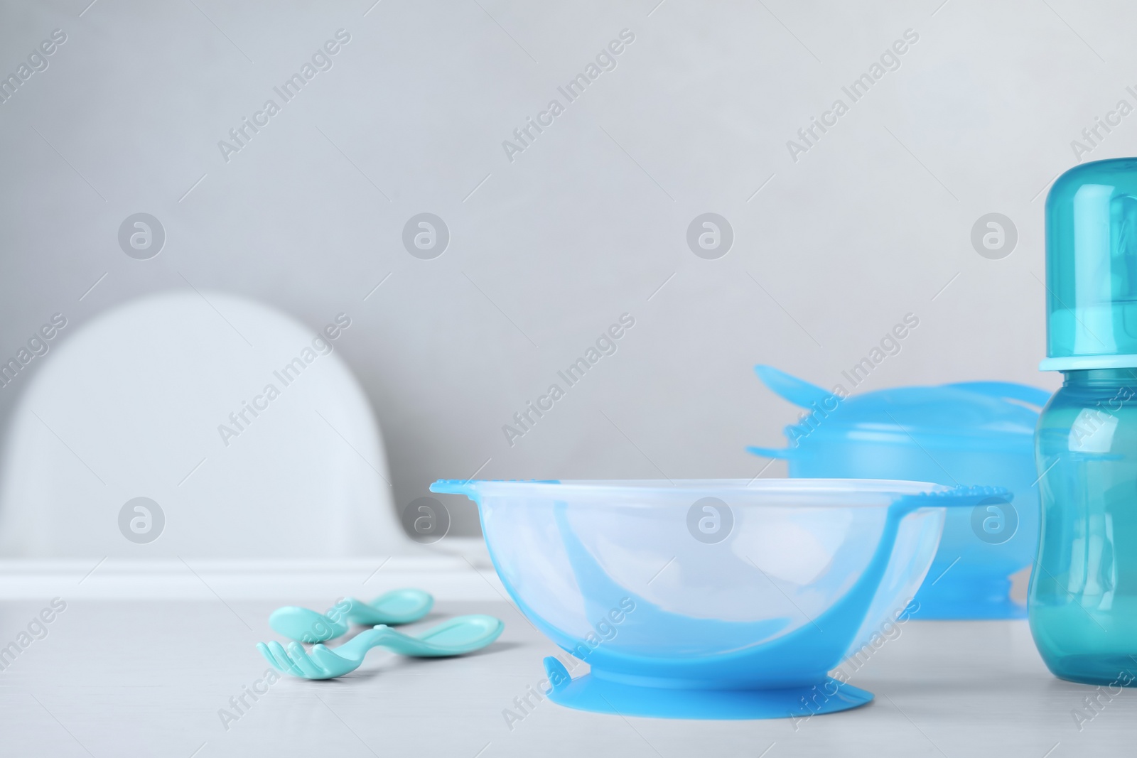 Photo of Set of plastic dishware on white table indoors, space for text. Serving baby food