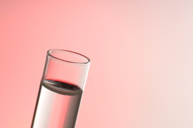 Glass test tube on light background, closeup. Space for text