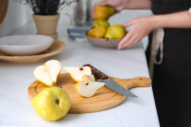 Photo of Fresh cut and whole pear on white countertop in kitchen