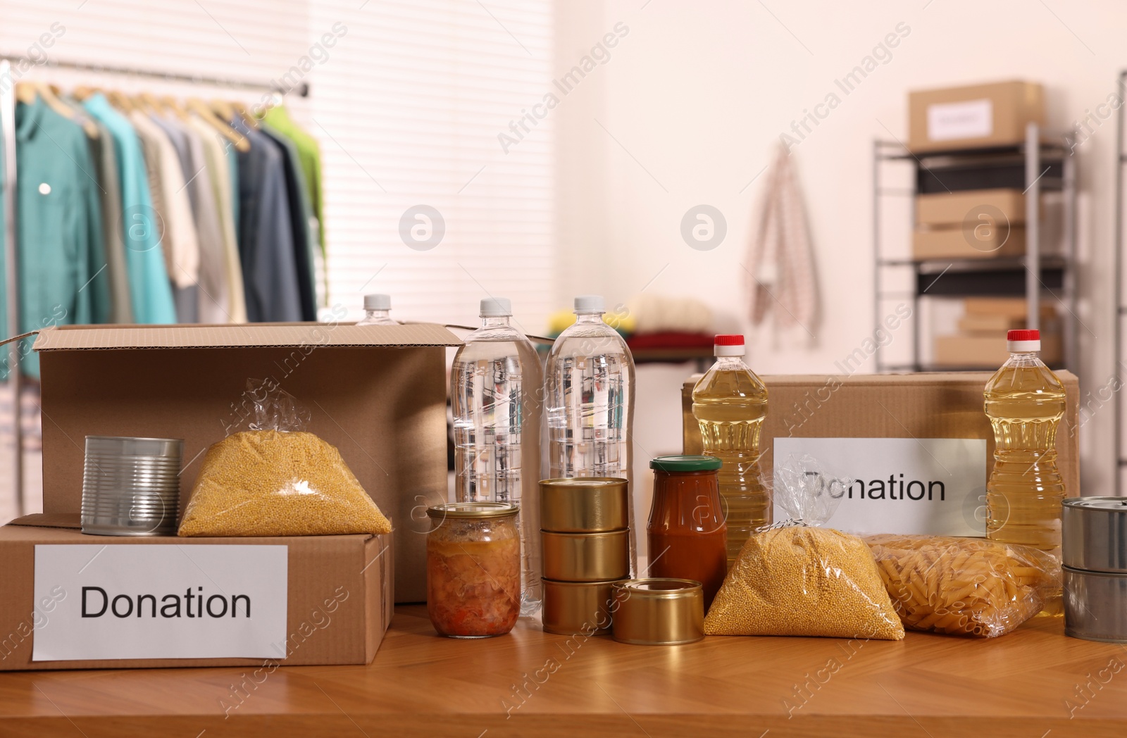 Photo of Volunteering. Different food products and cardboard boxes on table in warehouse