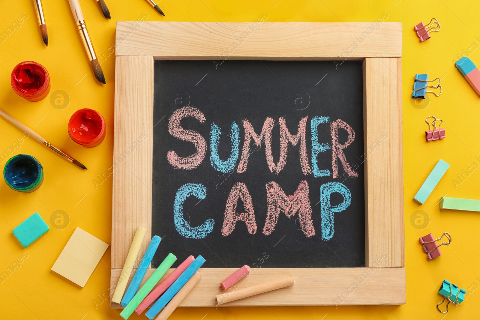 Photo of Text "SUMMER CAMP" on small blackboard and colorful chalk, top view