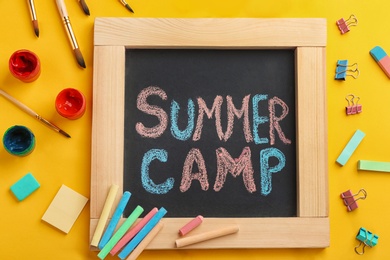 Text "SUMMER CAMP" on small blackboard and colorful chalk, top view