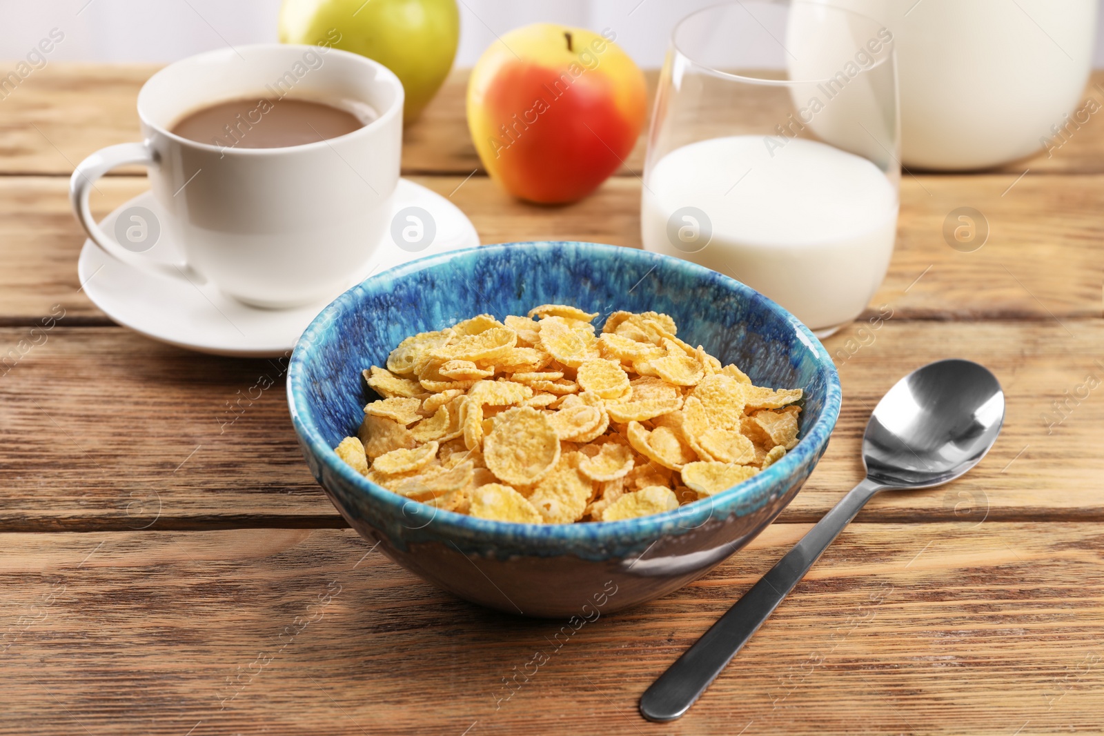 Photo of Bowl with healthy cornflakes for breakfast served on wooden table