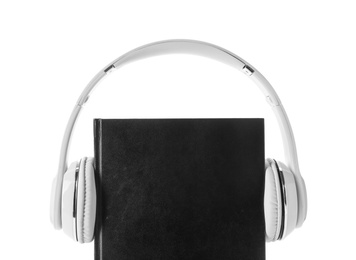 Photo of Bible and headphones on white background. Religious audiobook