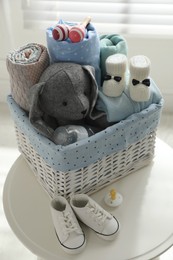 Photo of Baby clothes, shoes and accessories on white table indoors