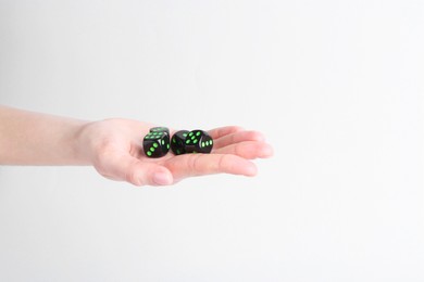 Photo of Woman holding game dices in hand on white background, closeup