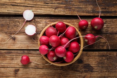 Bowl with fresh ripe radishes on wooden table, flat lay