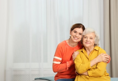 Photo of Elderly woman with female caregiver at home. Space for text