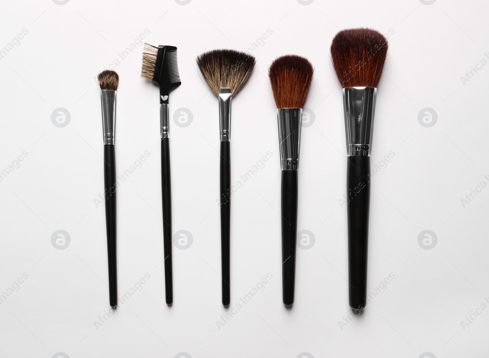 Photo of Different makeup brushes on white background, flat lay