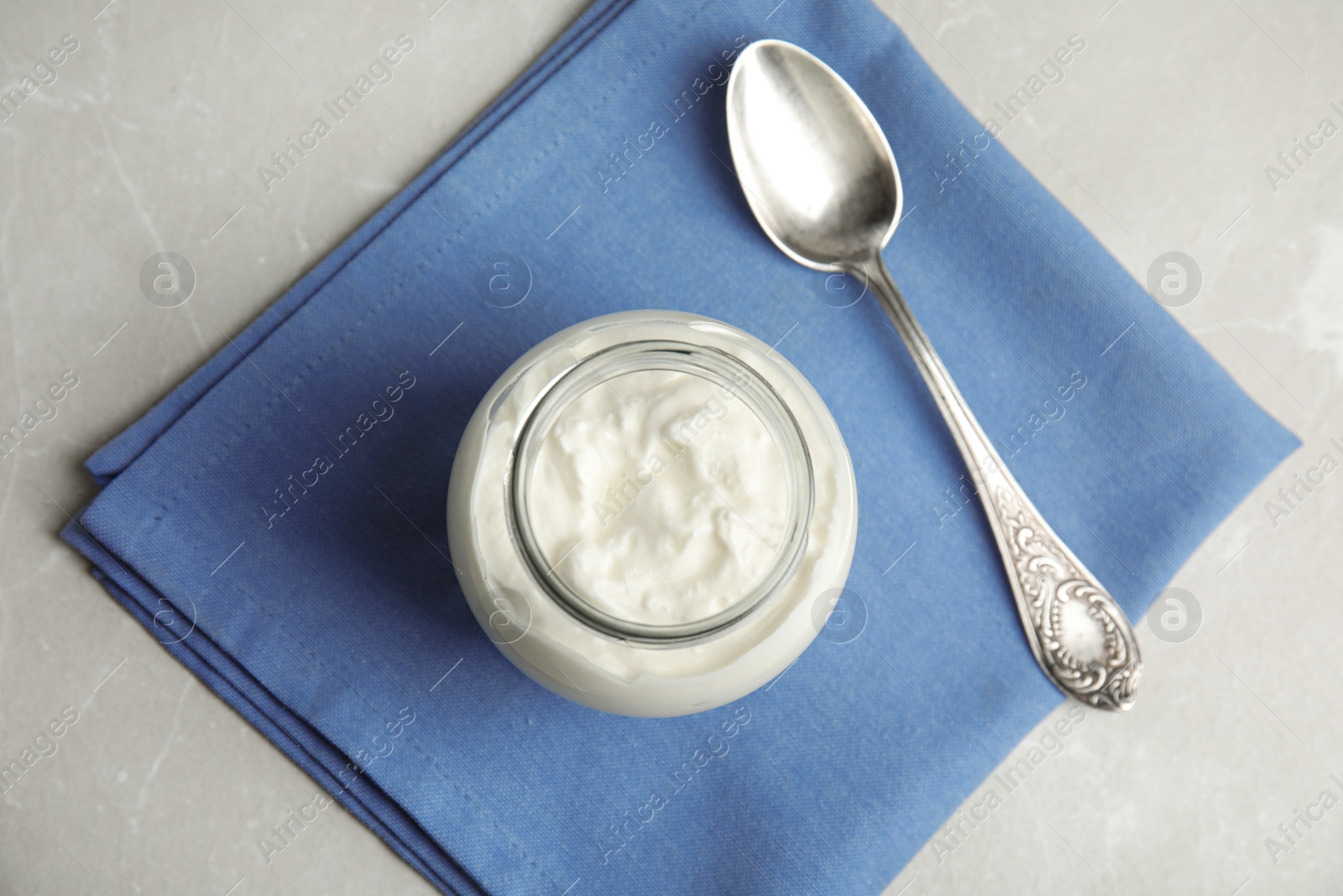 Photo of Tasty organic yogurt on grey marble table, top view