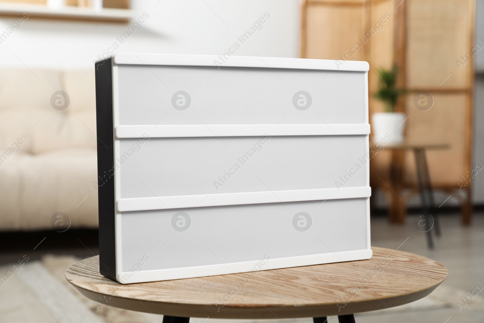 Photo of Blank light board on wooden table indoors