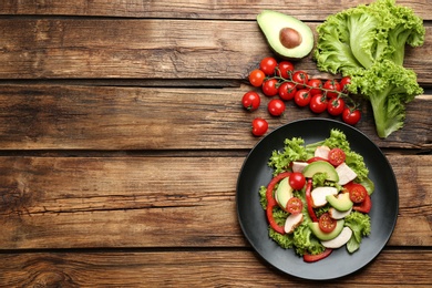 Photo of Delicious fresh chicken salad and vegetables on wooden table, flat lay. Space for text