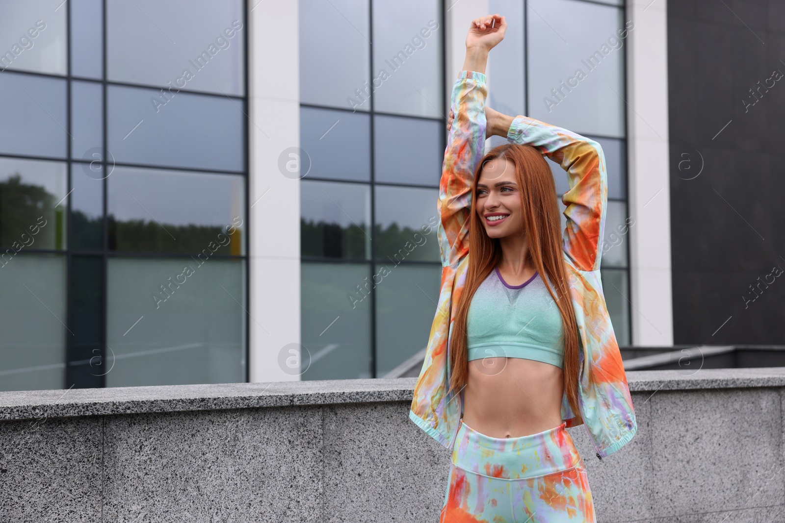 Photo of Beautiful woman in gym clothes doing exercises on street, space for text