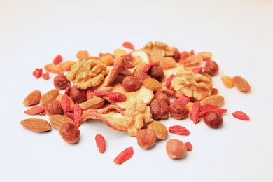 Pile of mixed dried fruits and nuts on white background, closeup