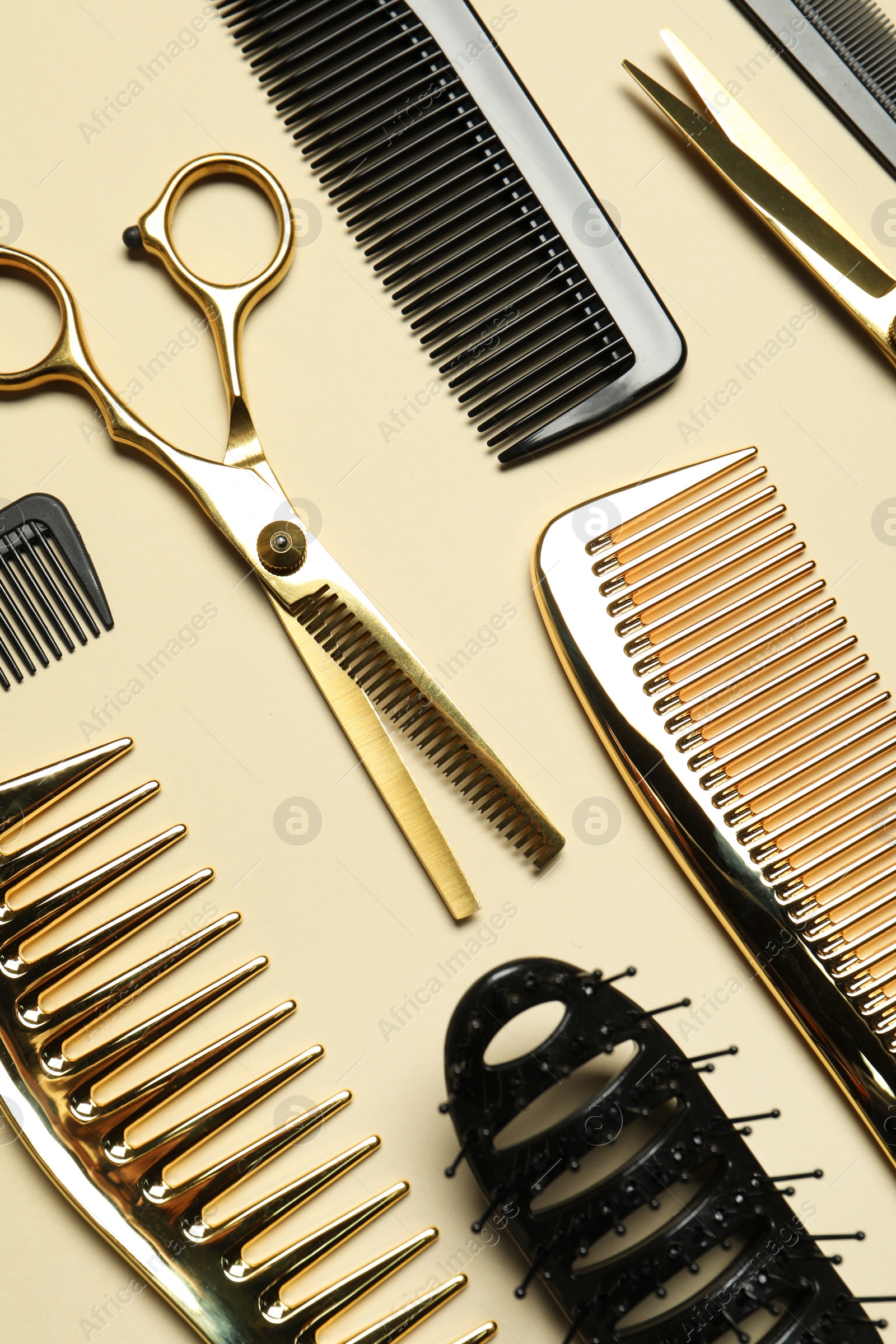 Photo of Hairdressing tools on beige background, flat lay