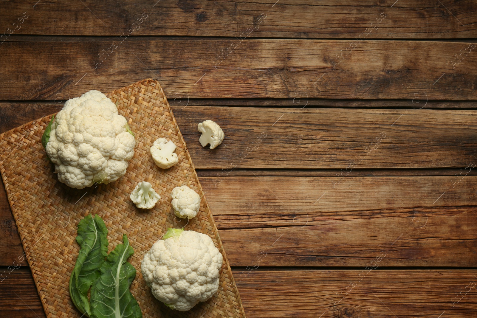 Photo of Fresh cauliflower on wooden table, top view. Space for text