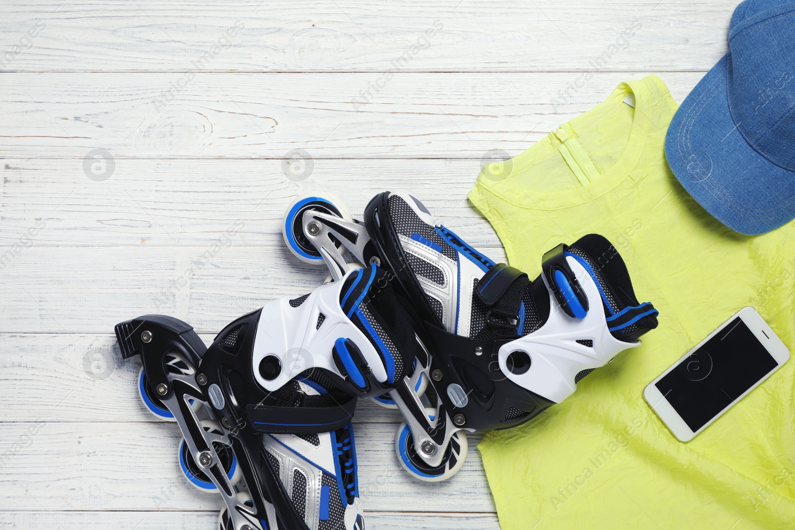 Photo of Flat lay composition with inline roller skates and space for text on wooden background