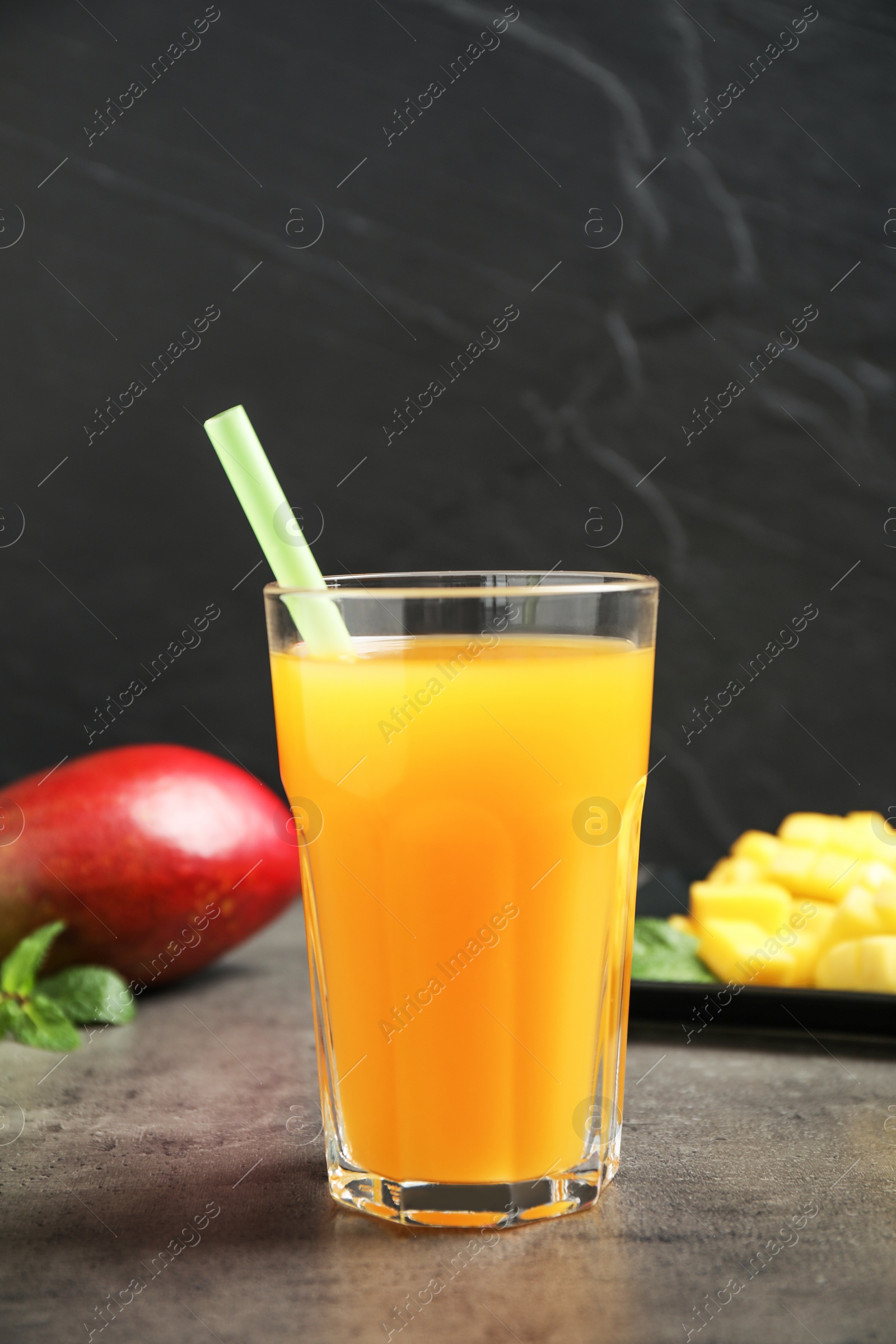 Photo of Fresh delicious mango drink on grey table