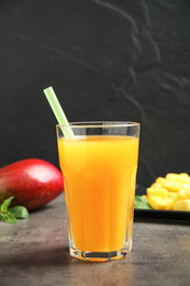 Photo of Fresh delicious mango drink on grey table