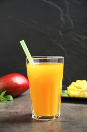 Fresh delicious mango drink on grey table