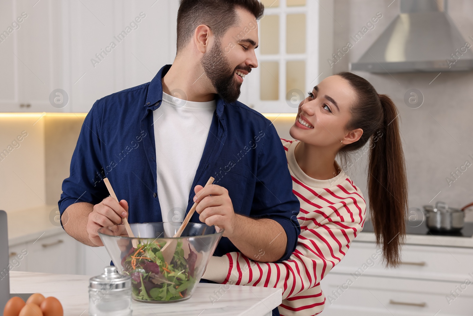 Photo of Happy lovely couple cooking together in kitchen