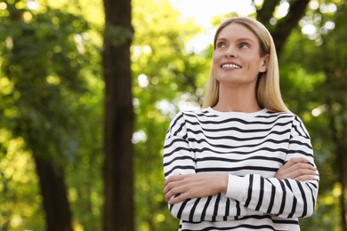 Portrait of happy woman in casual clothes outdoors. Space for text. Attractive lady posing for camera