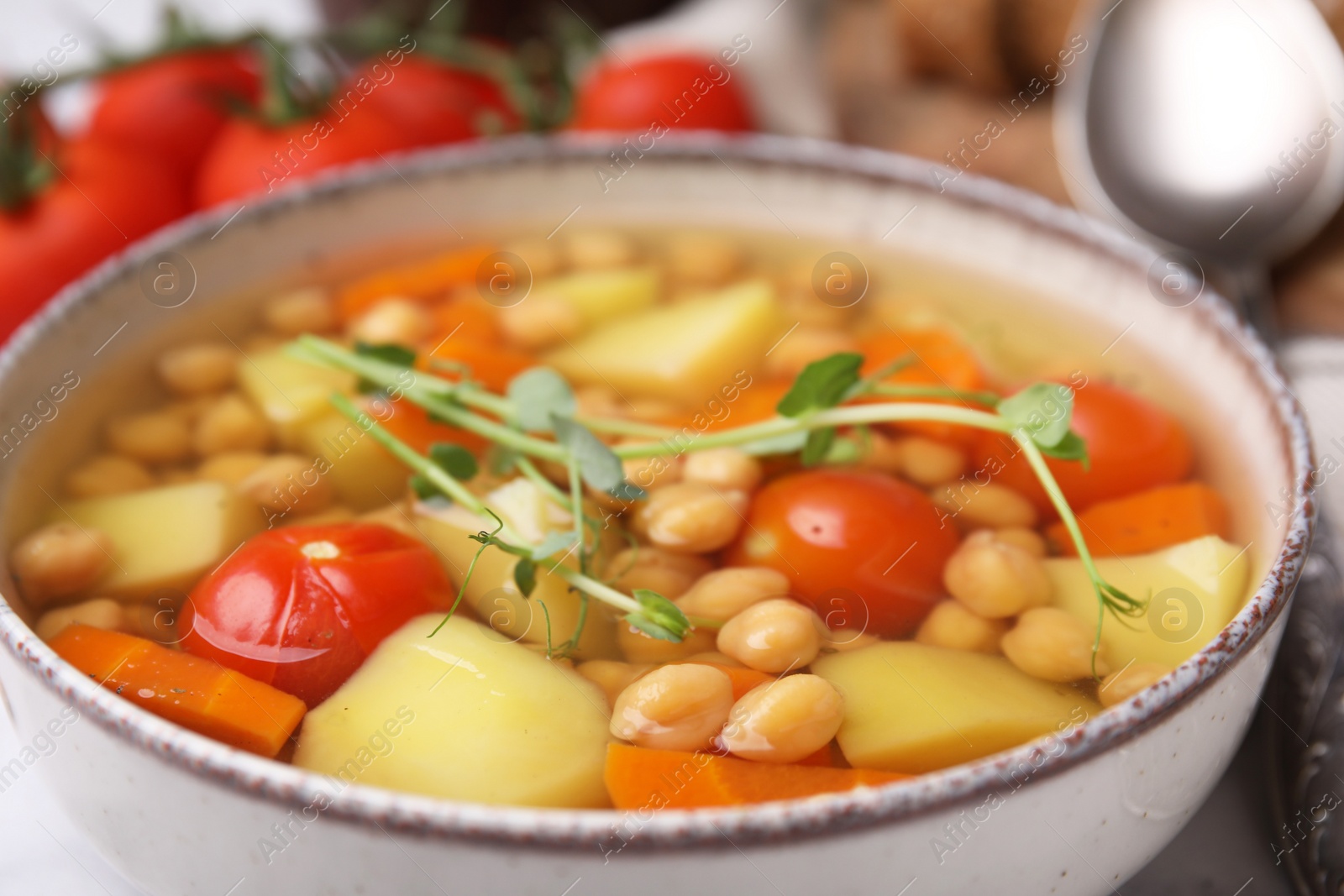 Photo of Tasty chickpea soup in bowl served on table, closeup