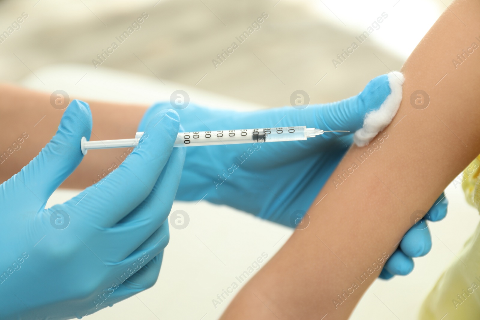 Photo of Doctor vaccinating little child in clinic, closeup