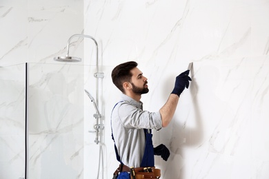 Handyman working in bathroom. Professional construction tools