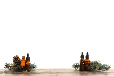 Composition with bottles of conifer essential oil on table against white background. Space for text