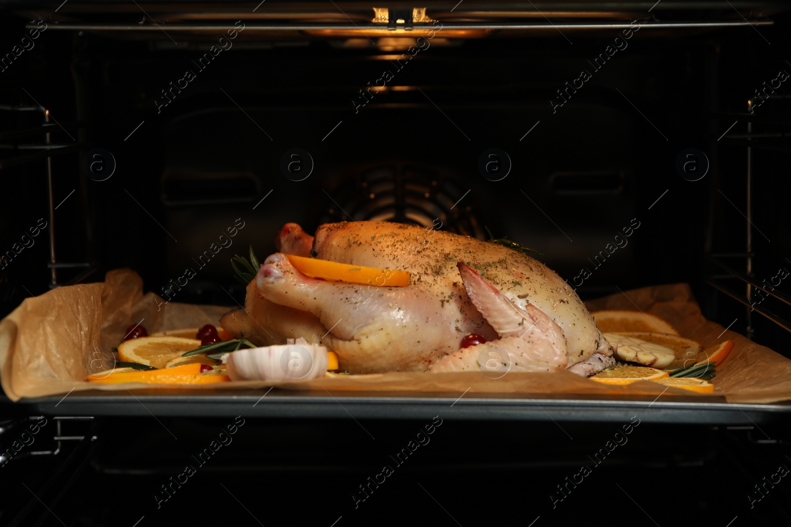 Photo of Chicken with orange slices baking in oven