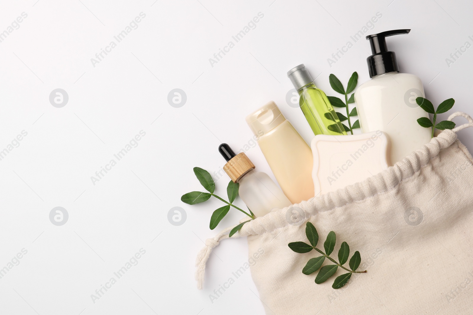 Photo of Preparation for spa. Compact toiletry bag, twigs and cosmetic products on white background, flat lay. Space for text