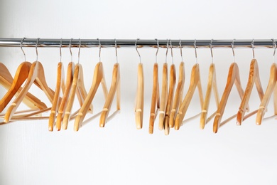 Clothes rail with wooden hangers on white background