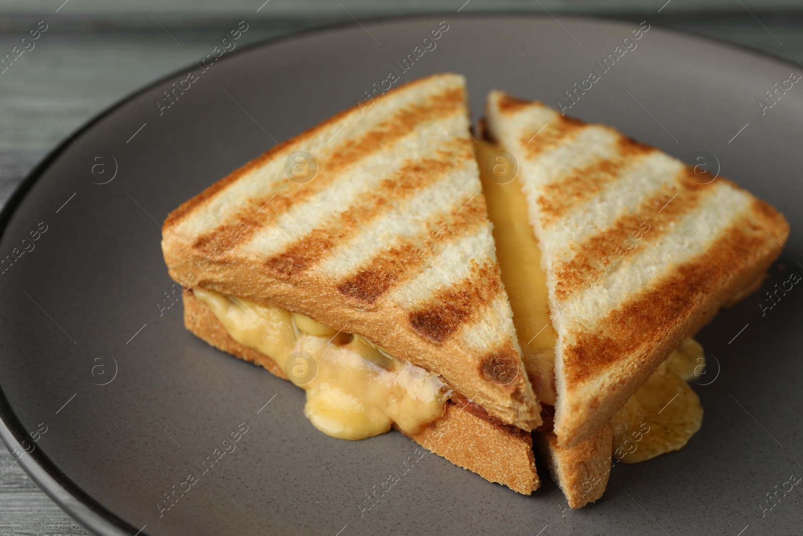 Photo of Tasty sandwiches with ham and melted cheese on table, closeup