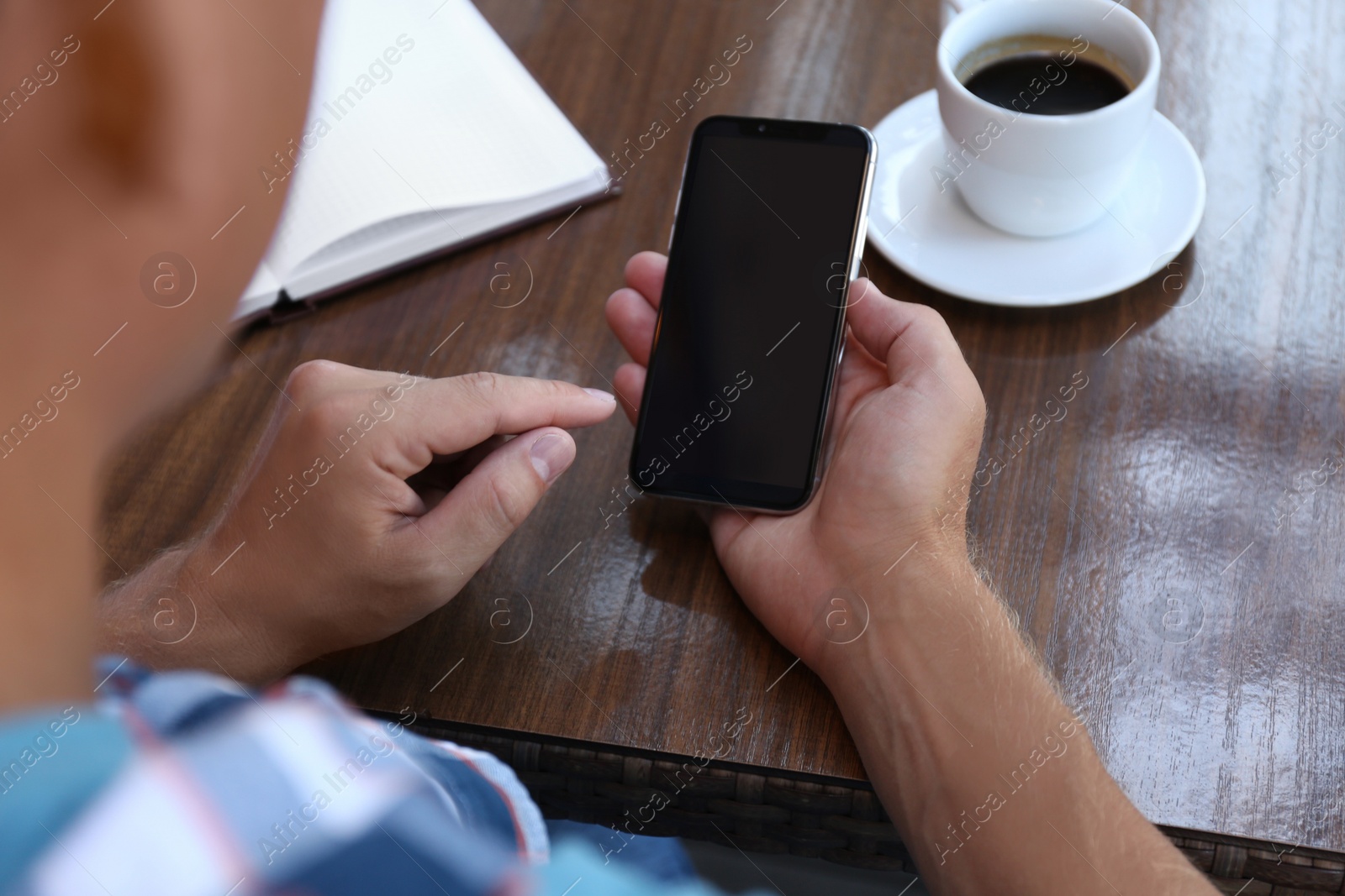 Photo of Man with smartphone at table in cafe, closeup