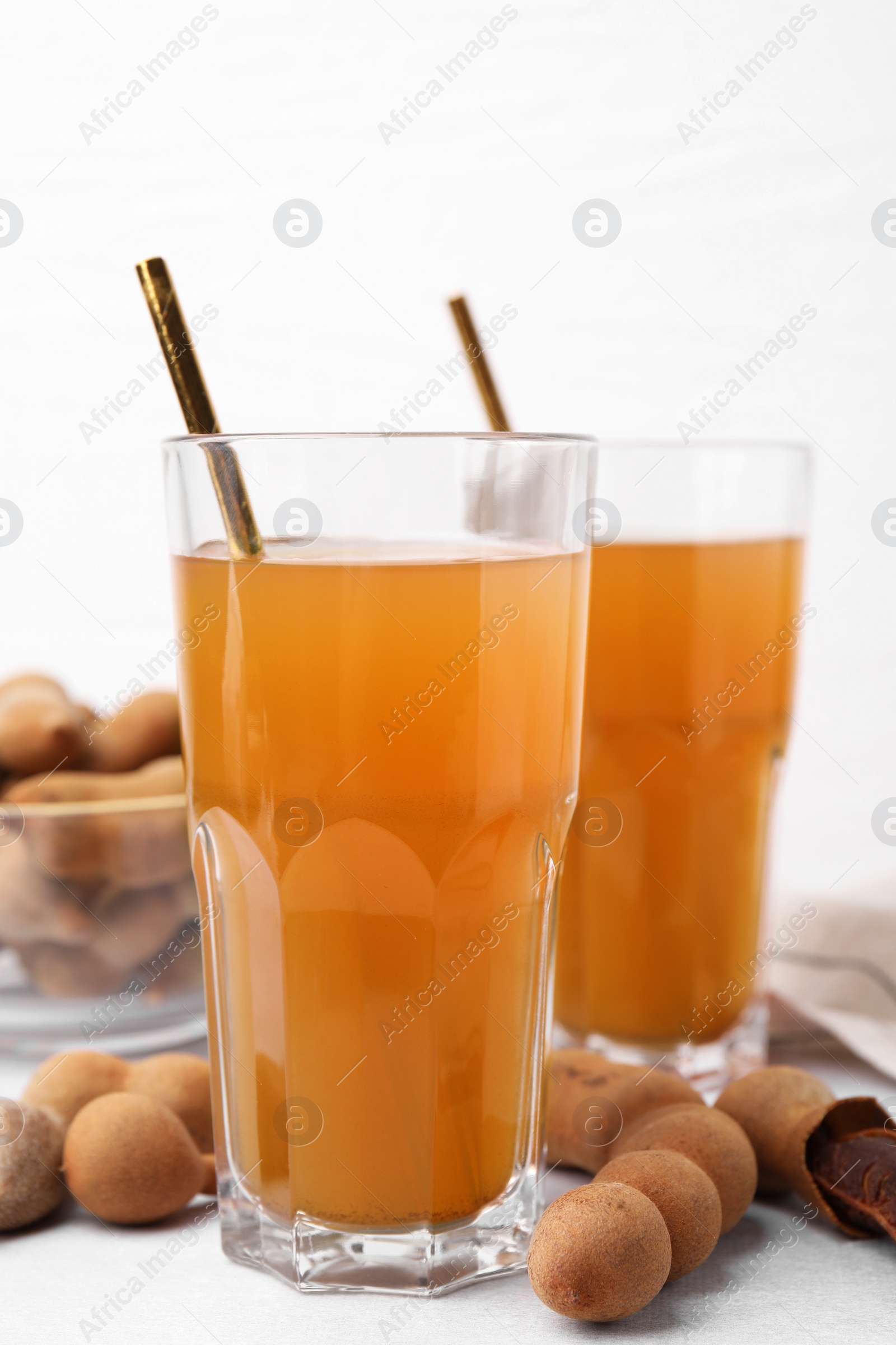 Photo of Tamarind juice and fresh fruits on white table