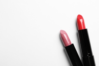 Photo of Different lipsticks and space for text on white background, top view